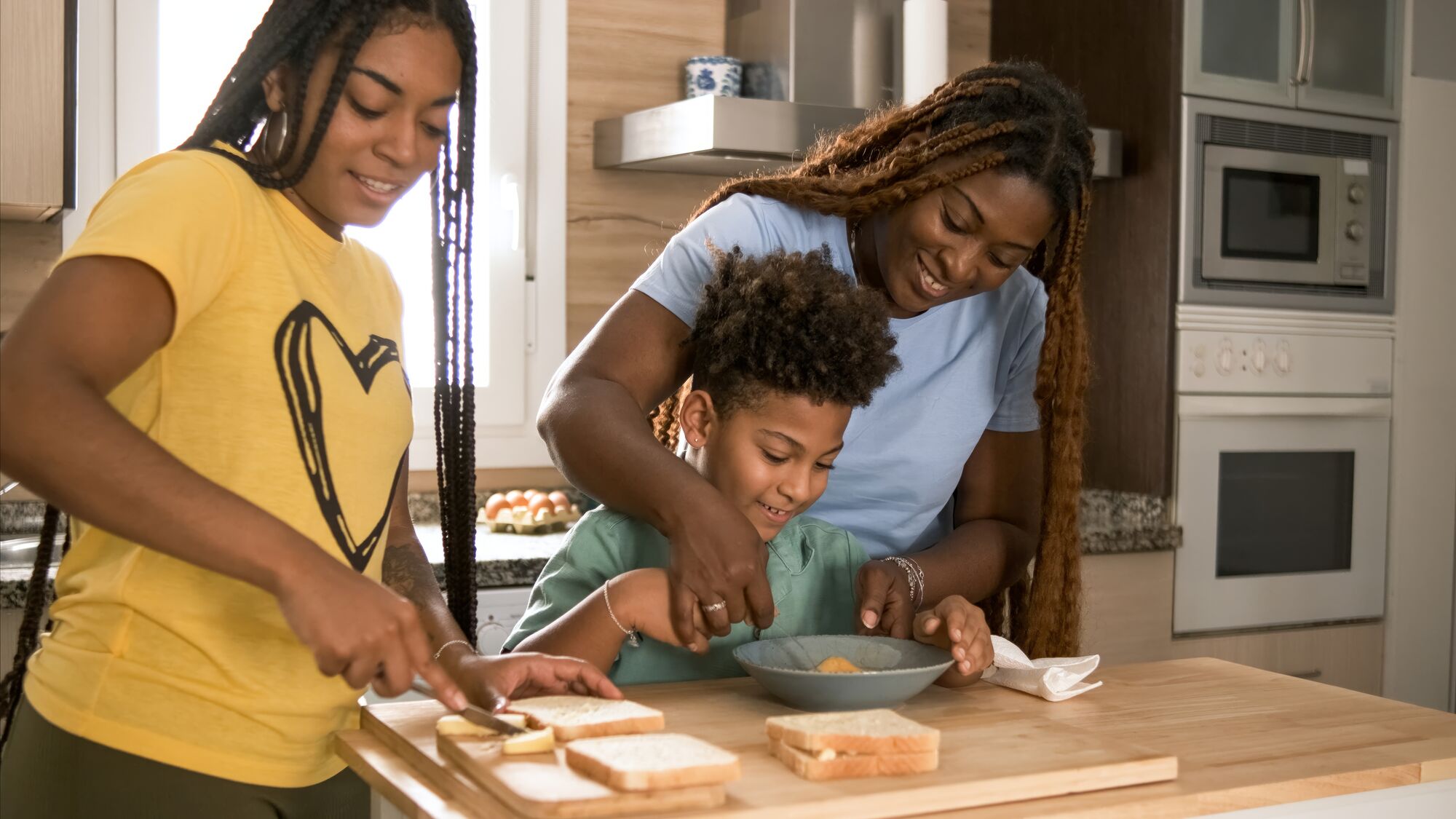 Mother and son making sandwiches together at a kitchen counter