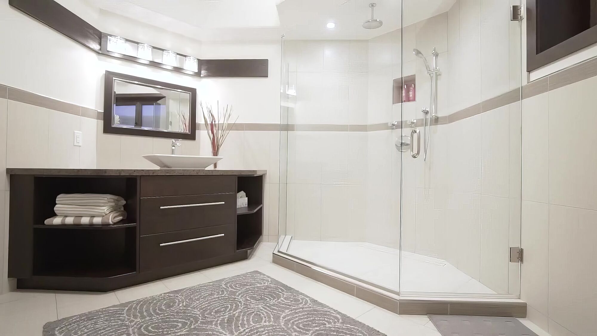 Remodeled bathroom with a dark wood vanity, a vessel sink and a frameless glass shower